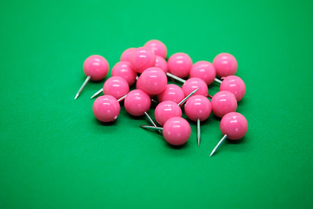 Pink pushpins on green background. Shallow depth of field.の写真素材