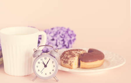 Late spring breakfast with coffee, delicious chocolate muffins, flowers - purple hyacinths and retro alarm clock.. Concept of coziness, spring and weekend.の写真素材