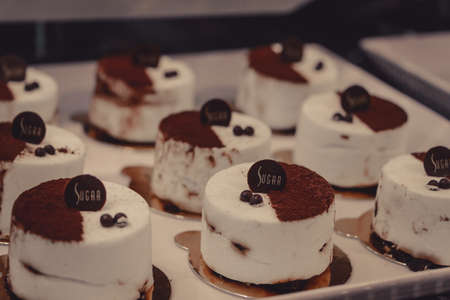 Showcase with delicious gourmet pastries in traditional Italian patisserie, close up. Concept of...