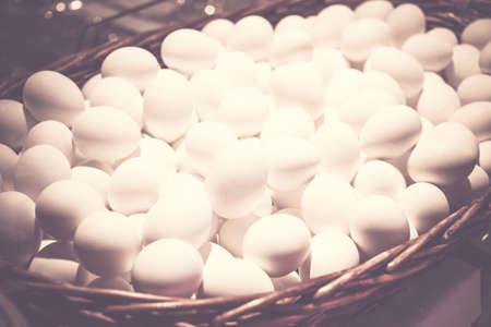 White chicken eggs in large wicker basket., close up.の写真素材
