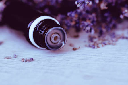Herbal essential oil and lavender flowers on wooden background. Close up and copy spaceの写真素材