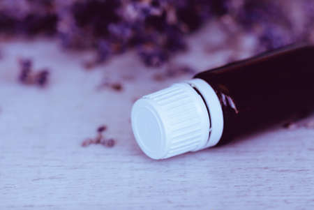Herbal essential oil and lavender flowers on wooden background. Close up and copy spaceの写真素材