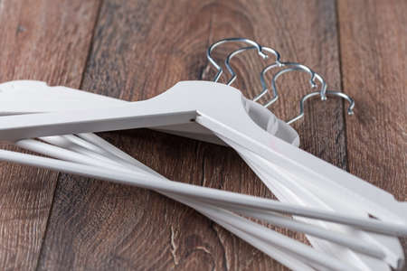 White empty wooden hangers for clothes on brown background. Top view. Store, fashion or nothing to wear concept, saleの写真素材