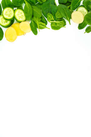 Fresh green leaves spinach, slices of cucumber and ginger isolated on a white background. Vegetables at border of image with copy space for text. Healthy and detox conceptの写真素材