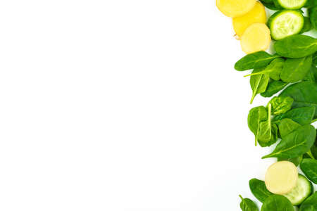 Fresh green leaves spinach, slices of cucumber and ginger isolated on a white background. Vegetables at border of image with copy space for text. Healthy and detox conceptの写真素材