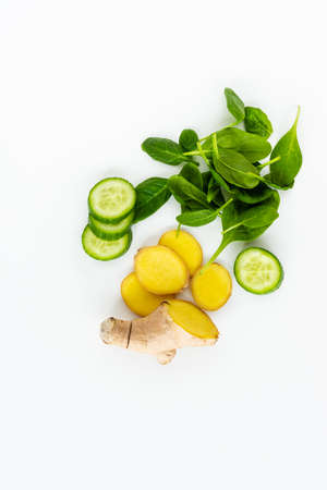 Fresh green leaves spinach, slices of cucumber and ginger isolated on a white background. Copy space for text. Healthy and detox conceptの写真素材