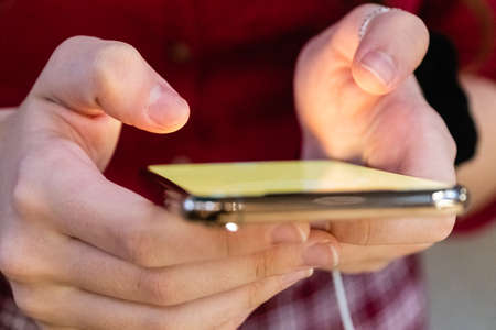 Connected anywhere at any time. Top view cropped shot of a woman holding phone in her hands.