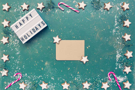 Festive Christmas composition, empty greeting card, conifer, candy canes, cookies and light box with...