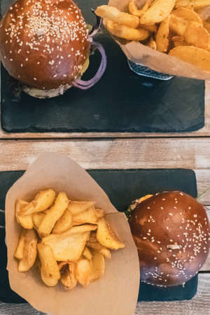 Veggie burgers in a bun with sesame seeds . Delicious fast food for vegans on a wooden backgroundの写真素材
