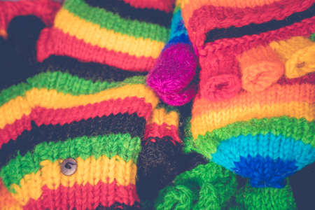 Multicolored knitted hand gloves for sale during Christmas market. Wool handicraft for protection in winter season. Street Xmas and holiday fair in European city.の写真素材