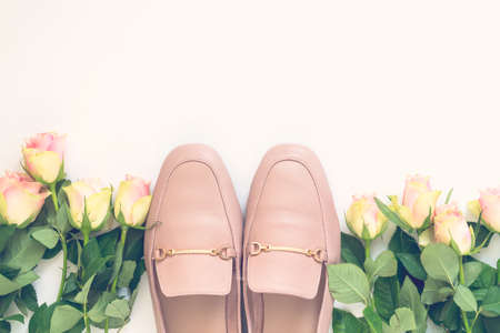 Pastel pink women shoes and roses on white background. Pair of elegant and stylish loafers. Flat lay, top view trendy fashion feminine background. Beauty blog concept.の写真素材
