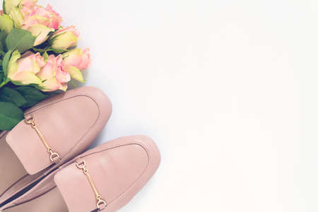 Pastel pink women shoes and roses on white background. Pair of elegant and stylish loafers. Flat lay, top view trendy fashion feminine background. Beauty blog concept.の写真素材
