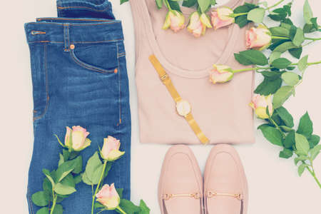 Flatlay of women's stylish outfit and roses on white bacground. Trendy clothes collage. Minimal and beauty blog conceptの写真素材