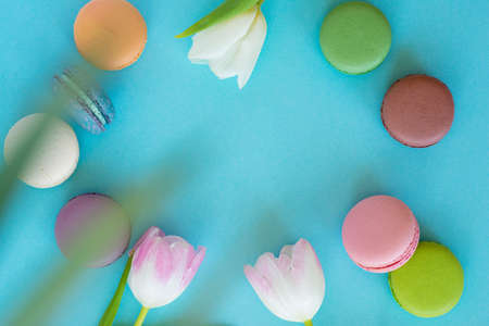 Tulips and macarons on pink background. Minimal floral flat lay, top view. Valentines background.の写真素材