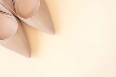 Classic beige women high heel shoes on pastel background. Minimal female background. Fashion blog and sale concept.の写真素材
