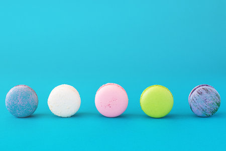Colourful french macarons on blue pastel background. Sweet concept.の写真素材