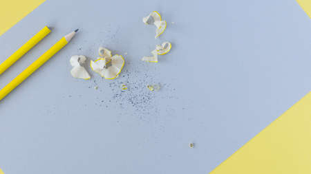 Yellow pencils and shavings on grey paper background