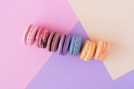 Colourful french macarons in a row on pastel background. Sweet minimal concept.の写真素材