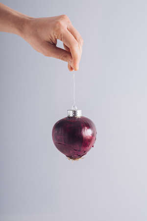 Female hand holding Christmas bauble decoration. Minimal natural holidays concept. Green New Years Resolutionの写真素材