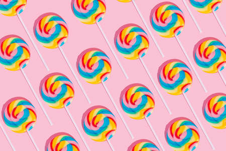 Minimal lollipop pattern on pastel pink background. Sweets, party, childhood and birthday concept.の写真素材