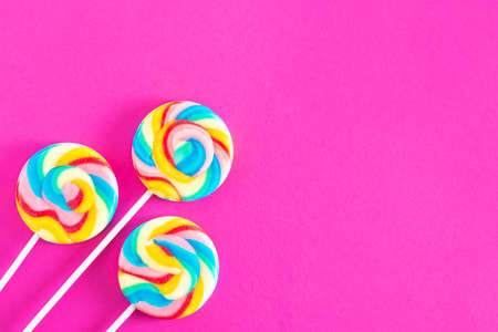 Colorful lollipops on pink background. Candy colored flat lay. Minimal concept for party and childhood.の写真素材