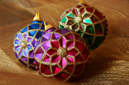 Vintage Christmas Ornaments - Colorful vintage Christmas ornaments on shiny gold netting fabric.の写真素材