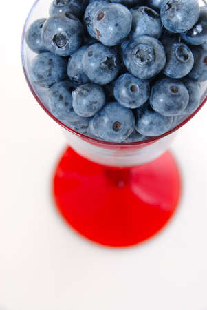 Michigan Blueberries - Fresh Michigan grown (V.corymbosum) blueberries in a glass goblet with a red stem. Macro image isolated on white.の写真素材