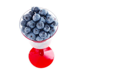 Michigan Blueberries - Fresh Michigan grown (V.corymbosum) blueberries in a glass goblet with a red stem. Macro image isolated on white.の写真素材