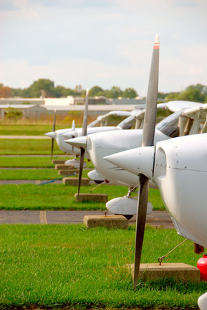 Small Plane Props - The propellers and noses of cessna skyhawk airplanes parked and tethered at a small airport.の写真素材