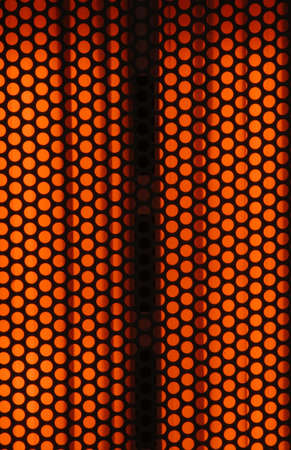 The front of an electric heater with the heating elements brightly lit and hot. Can be used as a background or overlay.の写真素材