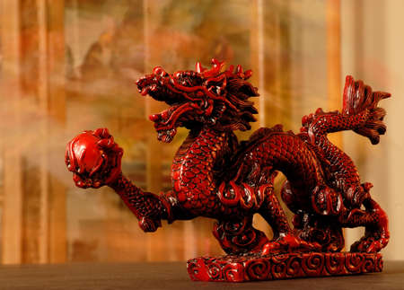 Chinese Dragon - Carved red chinese dragon with 4 toes holding a red ball.の写真素材