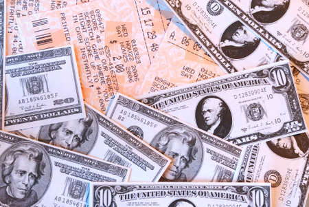 Macro background of lottery tickets and cash winnings in tens and twenties US currency.の写真素材