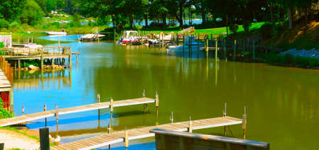 Boat Docks on the River - Along the Bear Lake Channel in Michigan we see several boat launch docks.の写真素材