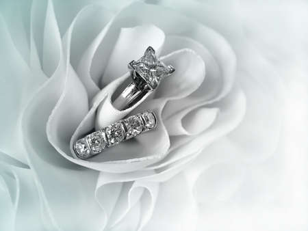 Beautiful diamond wedding ring set displayed in the folds of the fabric of a wedding gown. Space for copy.         の写真素材