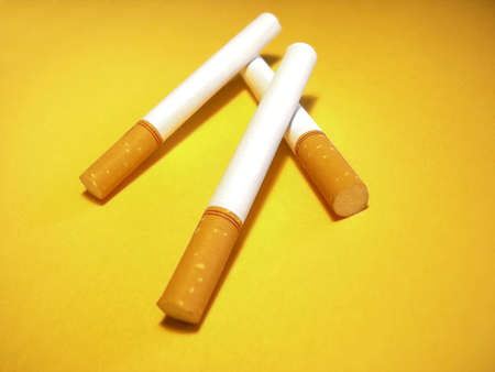 Cigarettes over a yellow backgroundの写真素材