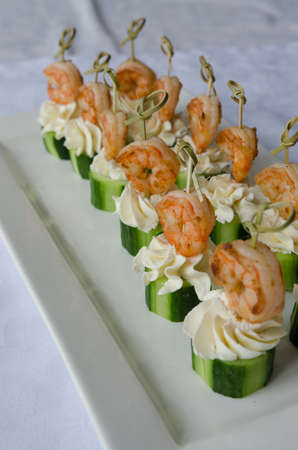 Spicy shrimp with cucumber and cream cheese skewers served on plateの写真素材