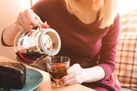 Close up view of woman pouring coffee into the cup. Business lunch
の写真素材