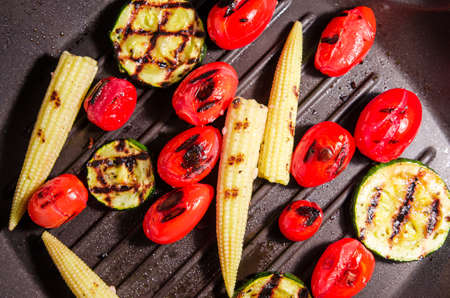 Grilled vegetables on grill pan. Zucchini, baby corn, cherry tomato. Top viewの写真素材
