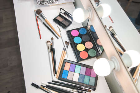 Different makeup products on table near mirror. Makeup studioの写真素材