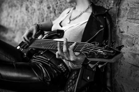 Woman's hands playing guitar. Black and white photo
