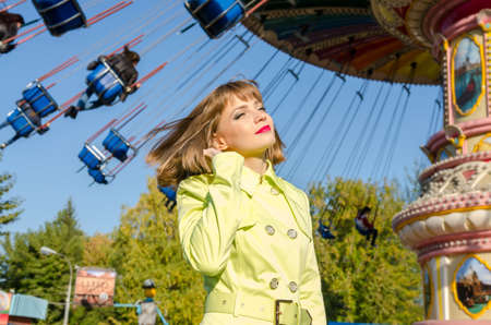 Portrait of blonde girl with short haircut in amusement park on sunset background