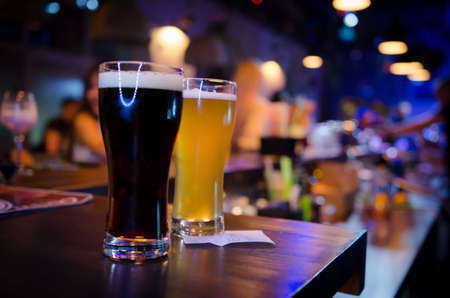 Glasses of light and dark beer on a pub counter. Pub backgroundの写真素材