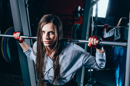 Fitness girl wearing sports clothes posing in the gymの写真素材