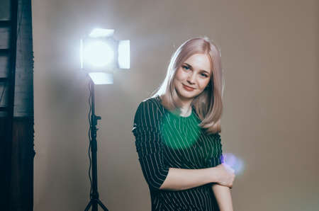 Fashion art portrait of a female model at studio in the light flashes. Young pretty woman in black...
