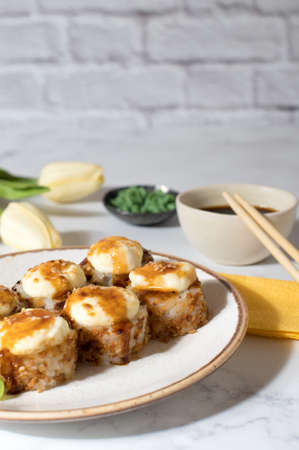 Sushi rolls set with sauce served on white plate. Light gray background. Cozy home photoの写真素材