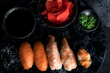 Delicious sushi set served on dark stone slate. Black backgroundの写真素材