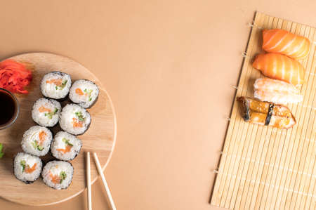 Sushi set sashimi with salmon, shrimp, eel and sushi rolls served on bamboo mat and wooden board. Place for textの写真素材
