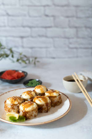 Sushi rolls set with sauce served on white plate. Light gray background. Copy spaceの写真素材