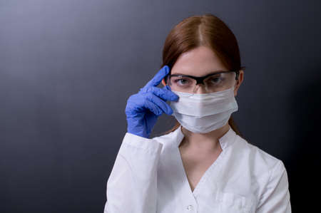Female doctor in a white coat showing face mask or medical mask to protection from coronavirus