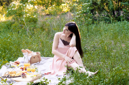 Girl in nature lying on the grass in the park. Picnic in the fresh airの写真素材